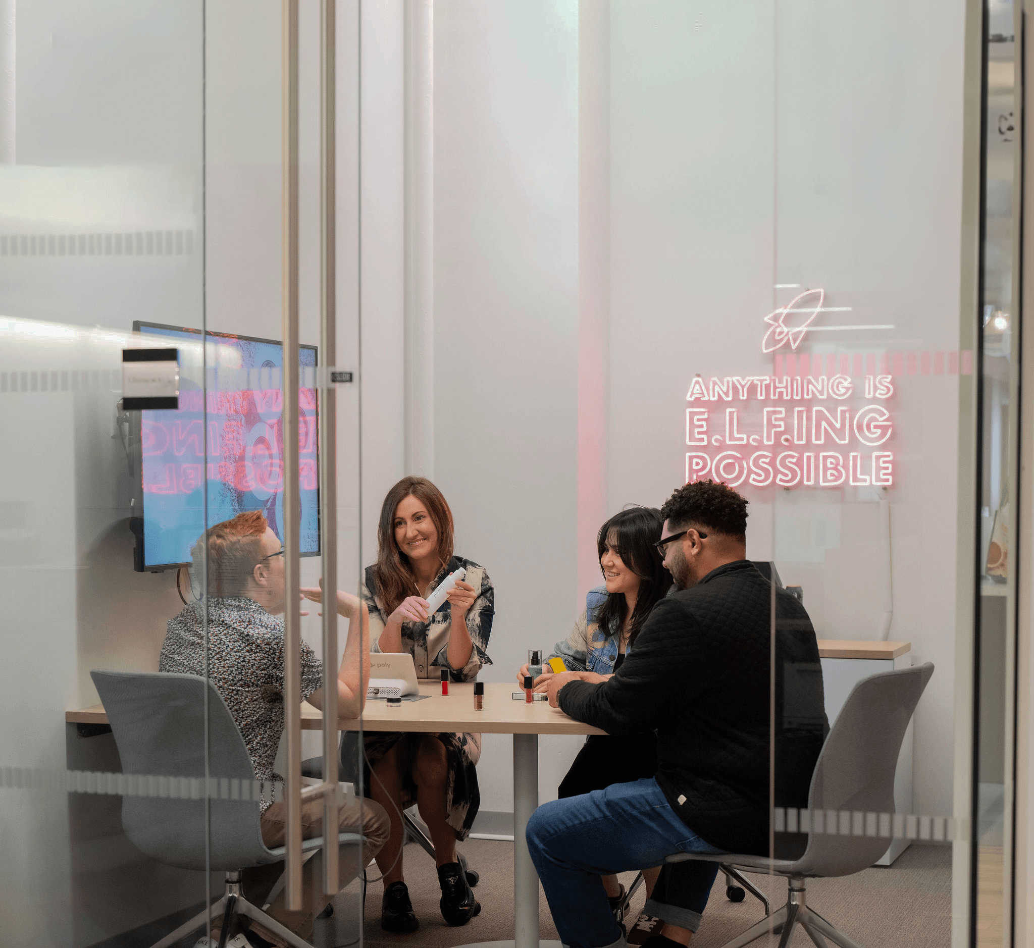 four people in an office smiling and conversion